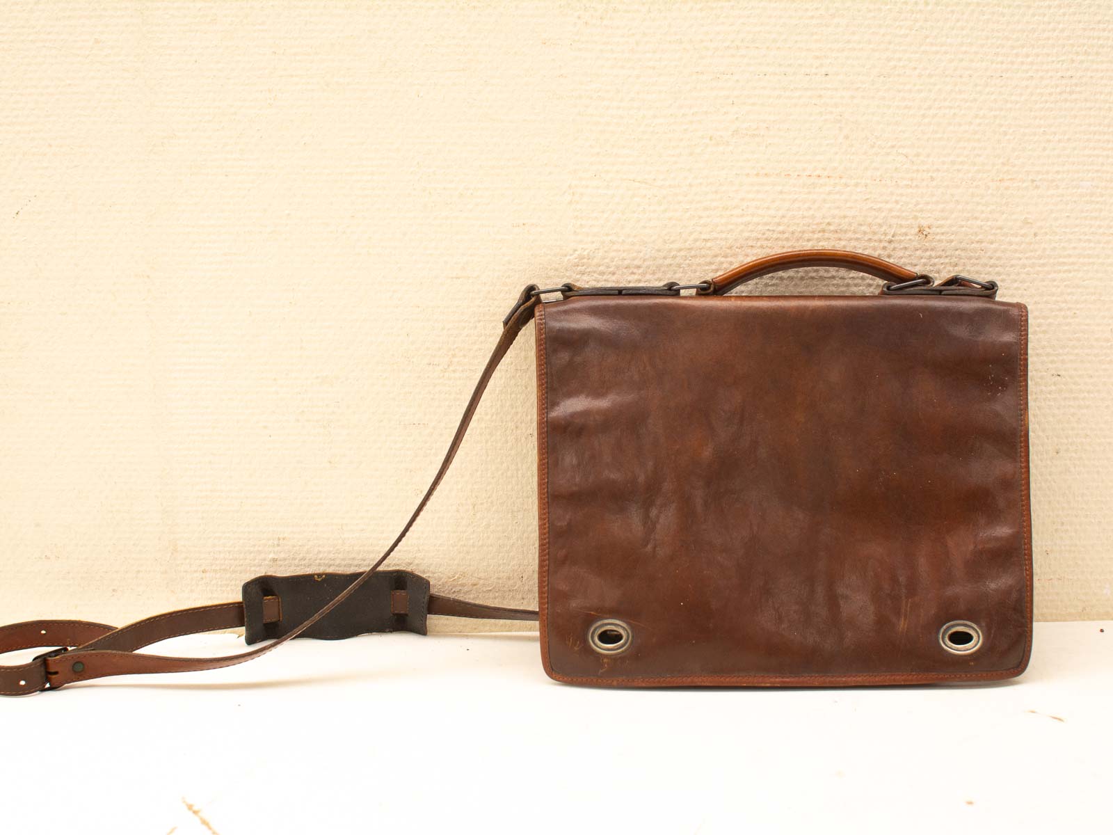 Vintage brown leather messenger bag with adjustable strap, perfect for style and everyday use.