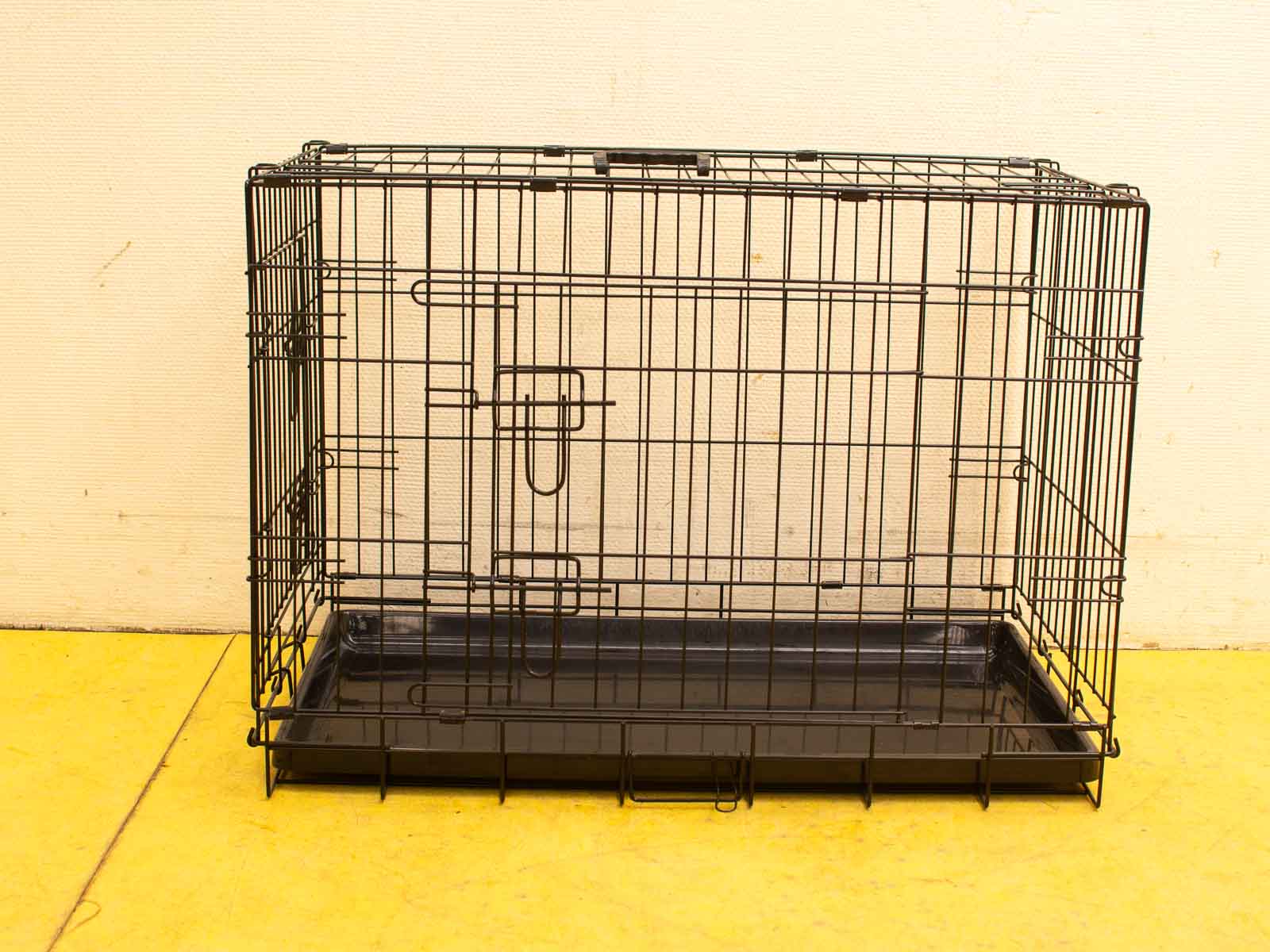 Durable black dog crate with removable tray, ensuring visibility, airflow, and secure containment.