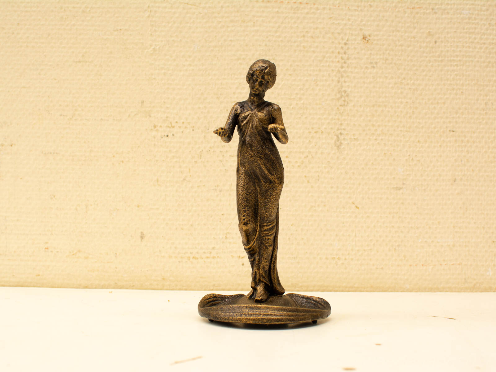 Elegant bronze statue of a woman in flowing attire, showcasing intricate detail and grace.