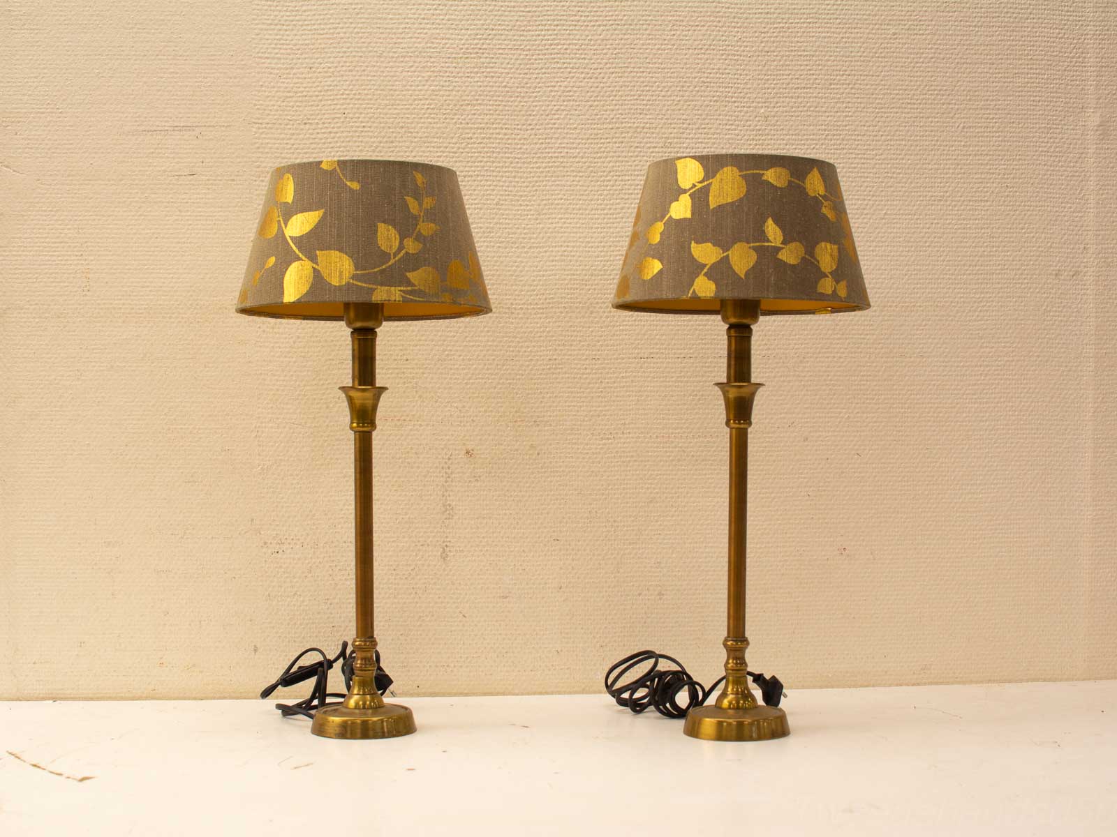 Stylish vintage table lamps with brass bases and gold-accented grey shades for elegant interiors.