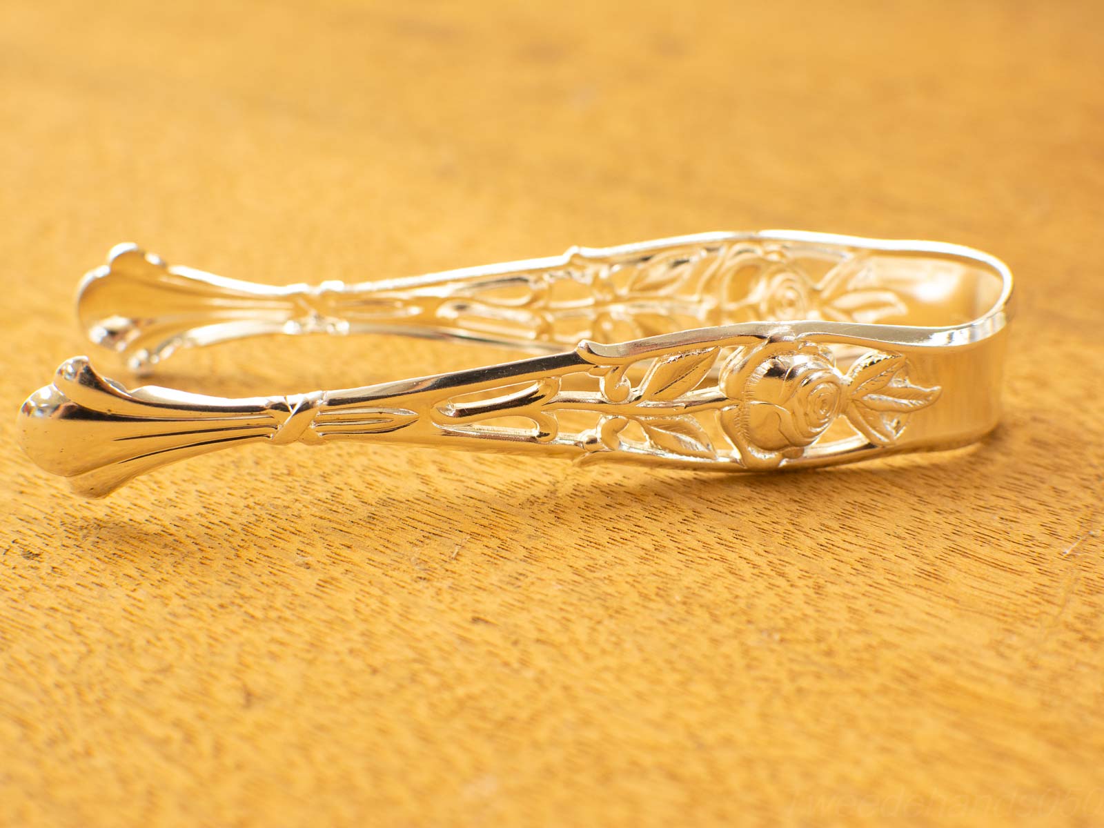 Intricate silver tongs with floral design, perfect for elegant dining and serving occasions.