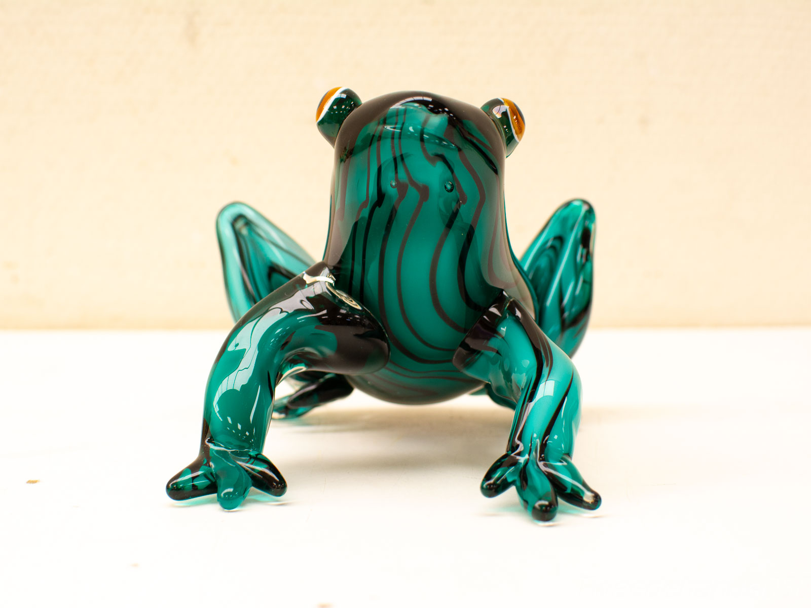 Vintage teal glass frog figurine with striking orange eyes, perfect for collectors and art lovers.