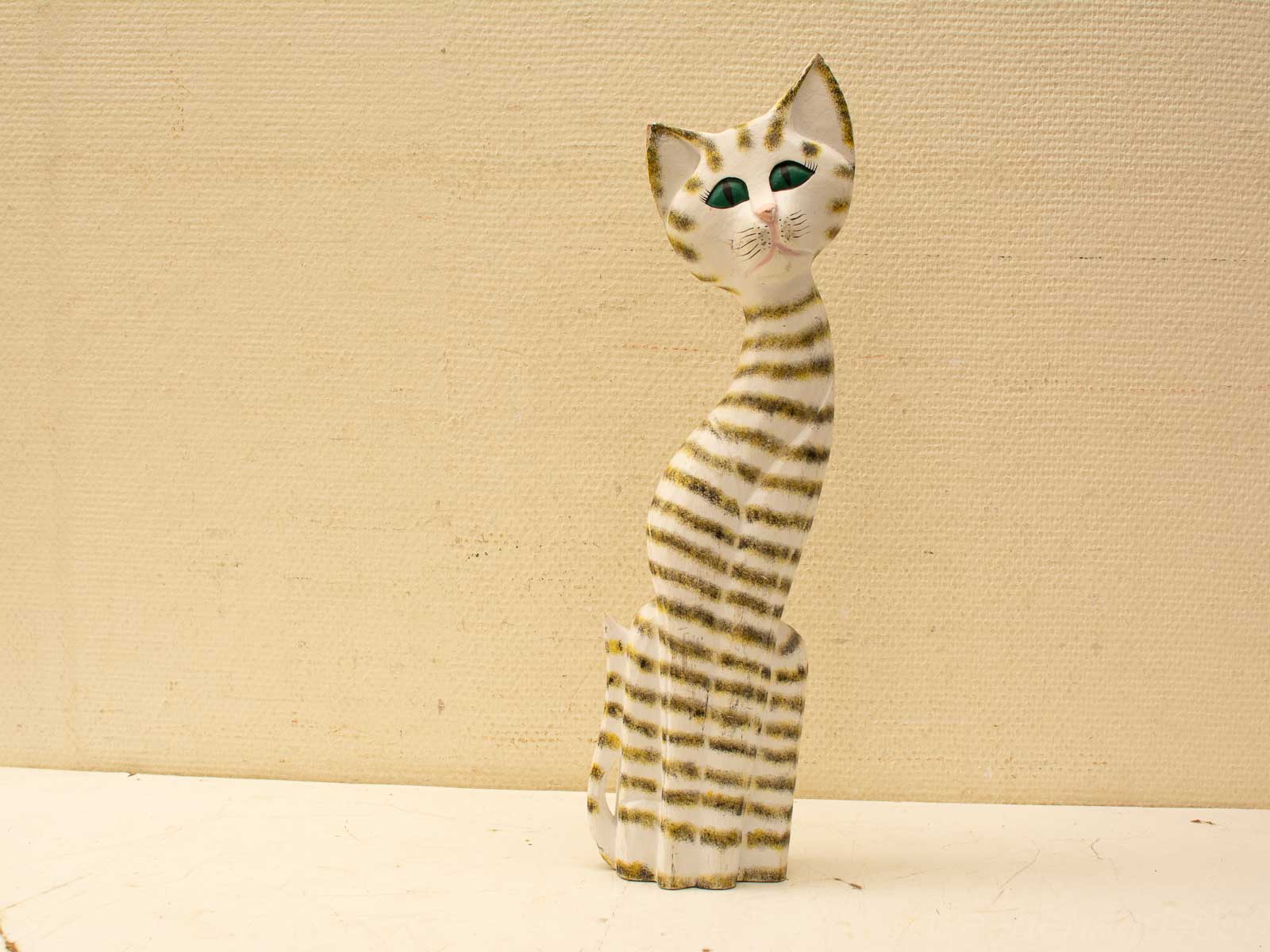 Charming striped cat sculpture with emerald eyes, perfect for adding whimsy to home decor.