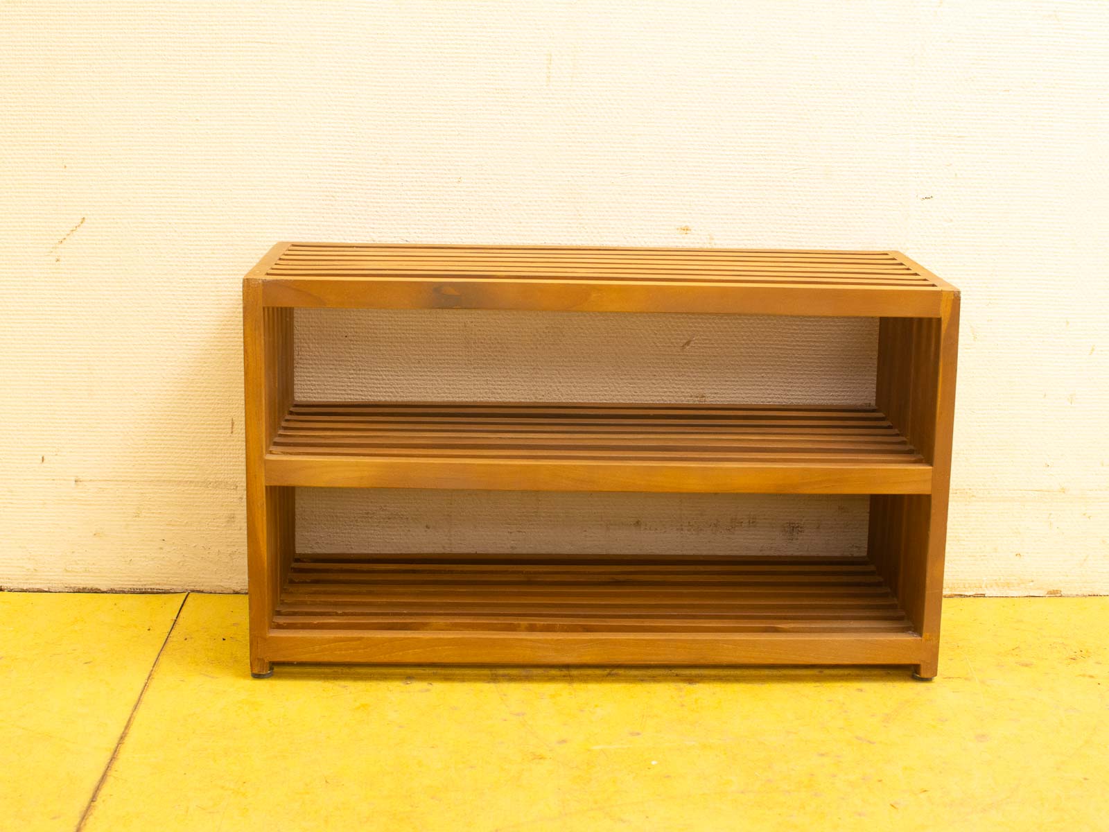 Modern wooden shelf unit with slatted design, perfect for books and decor in any space.