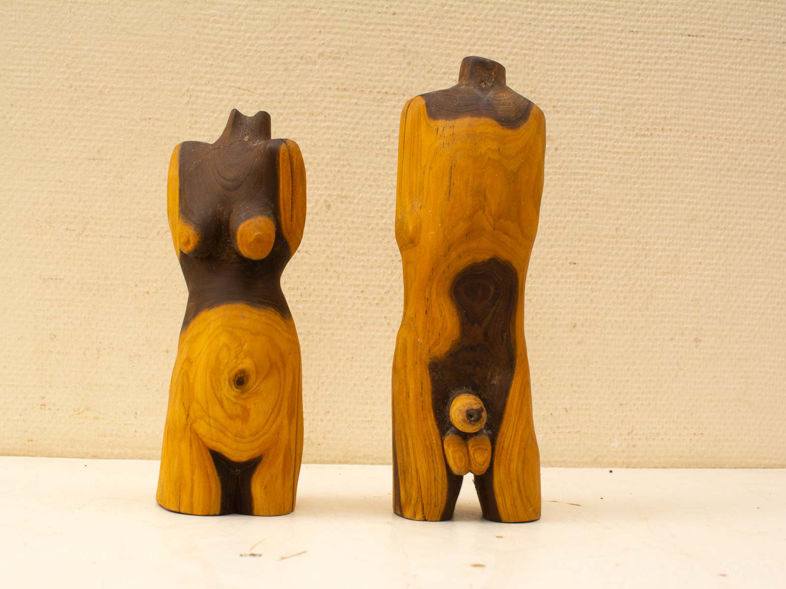 Stylized wooden sculptures of the female torso, blending abstraction and femininity in art.