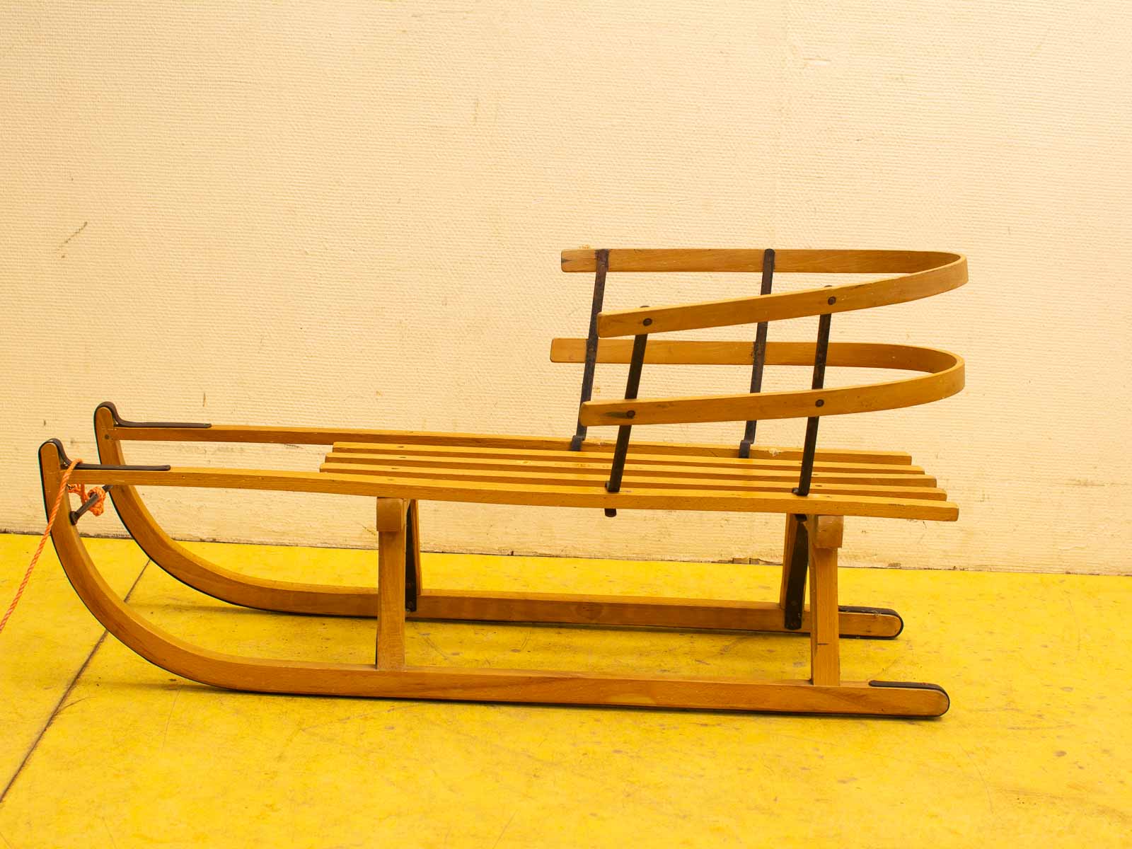 Classic wooden sled with polished finish, curved runners, perfect for nostalgic winter fun.