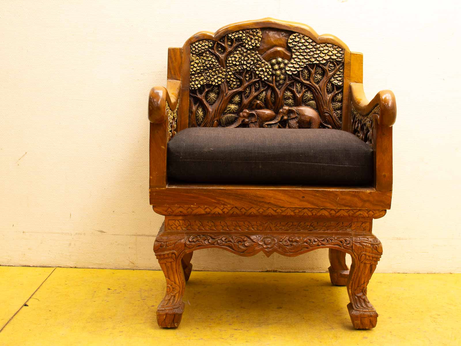 Elegant wooden chair with detailed carvings and a comfortable gray cushion, perfect for any decor.