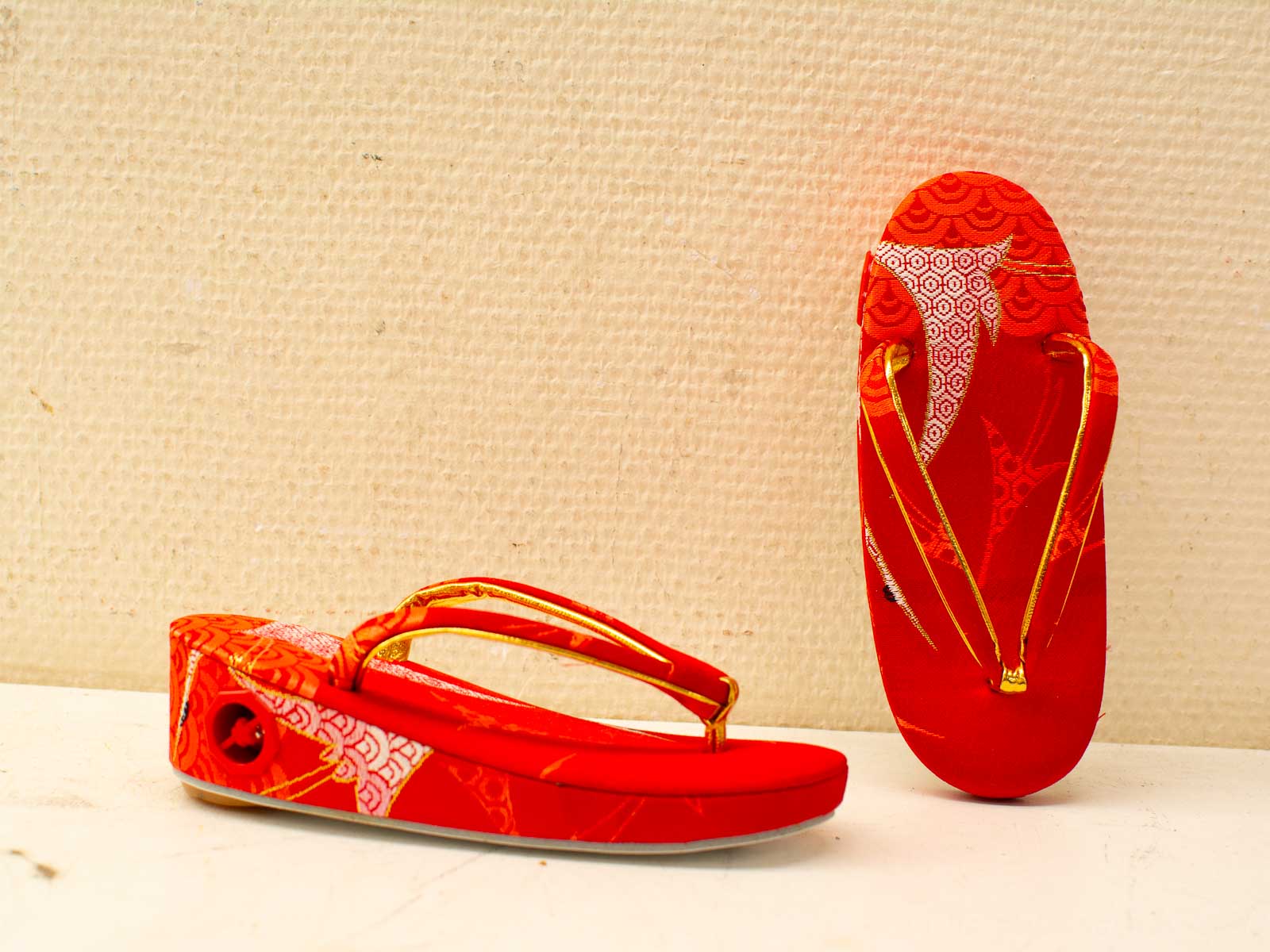 Vibrant red geta with golden accents, perfect for festivals and special occasions.