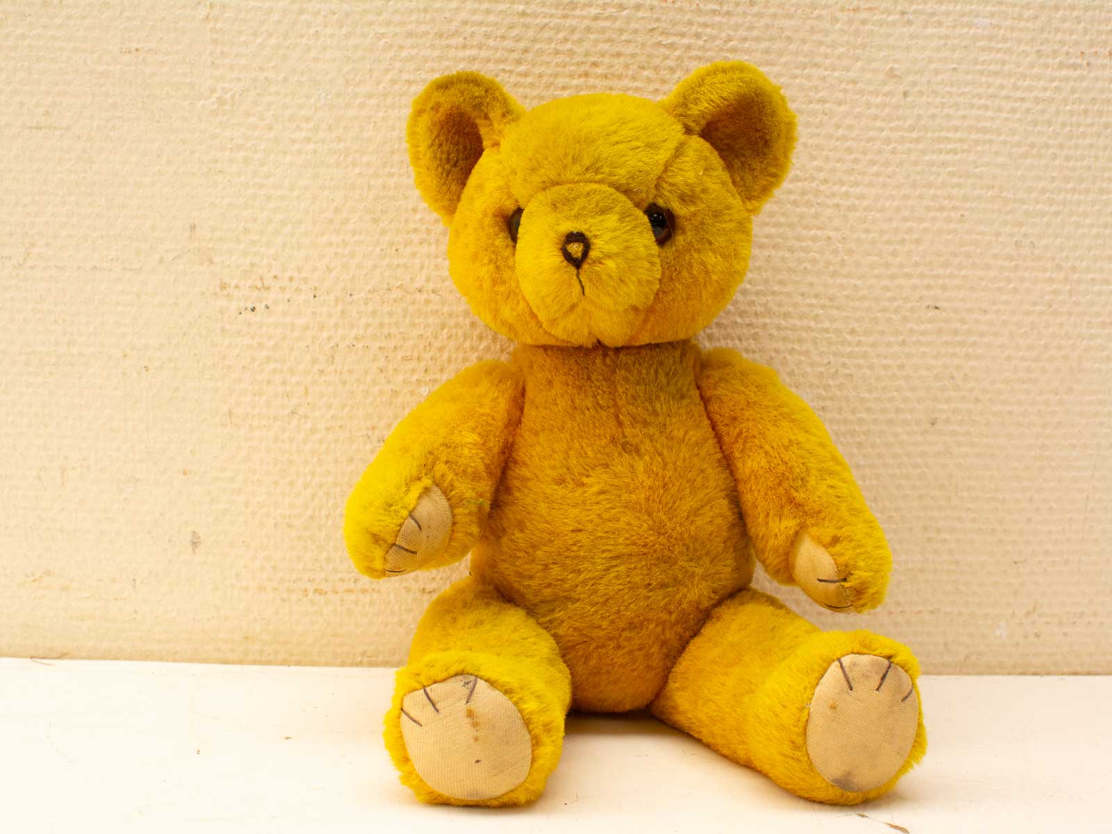 Charming yellow teddy bear for cuddles, embodying childhood nostalgia and warmth. Perfect gift for all ages.