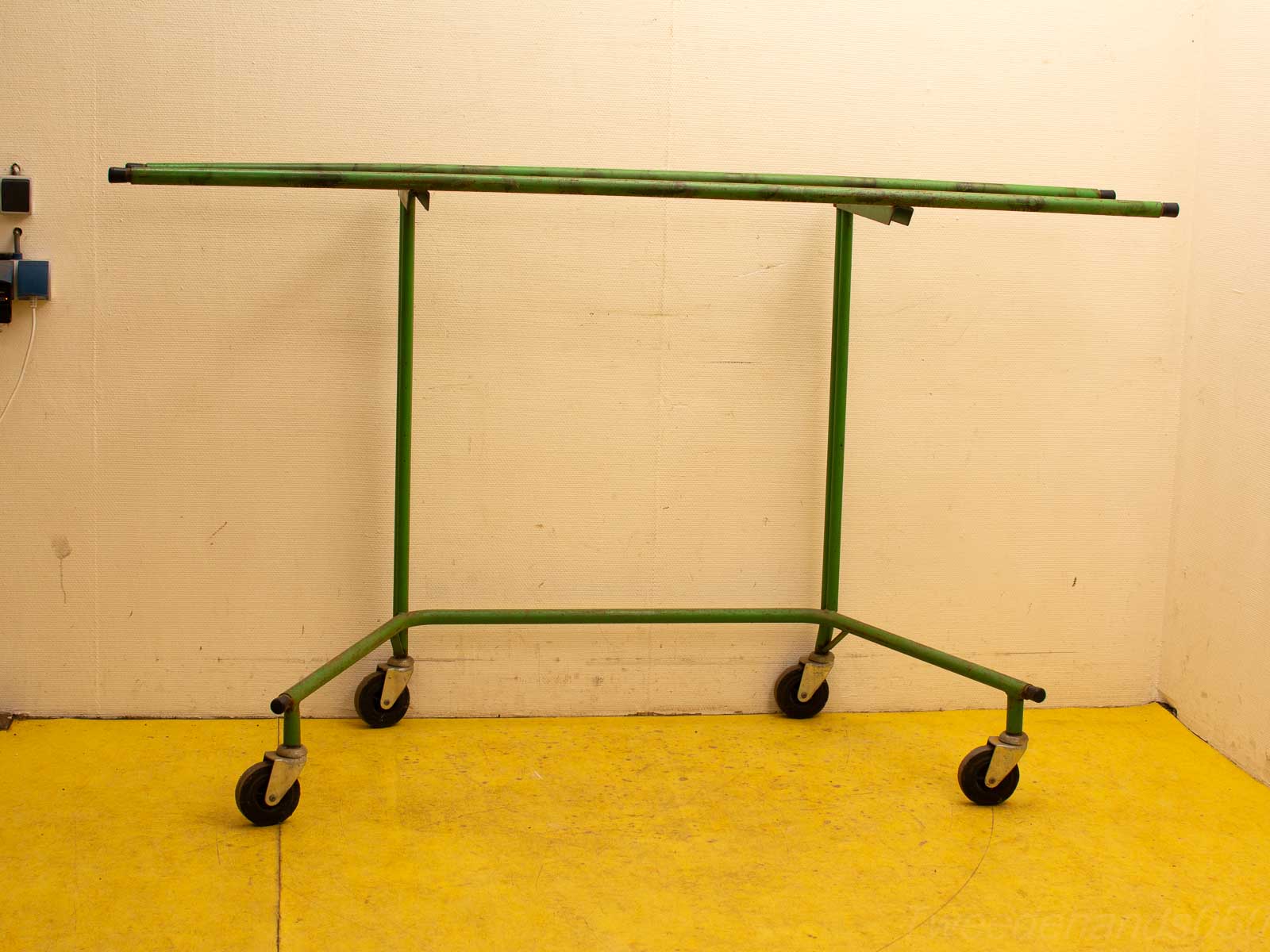 Stylish green garment rack on wheels for easy mobility in any space.