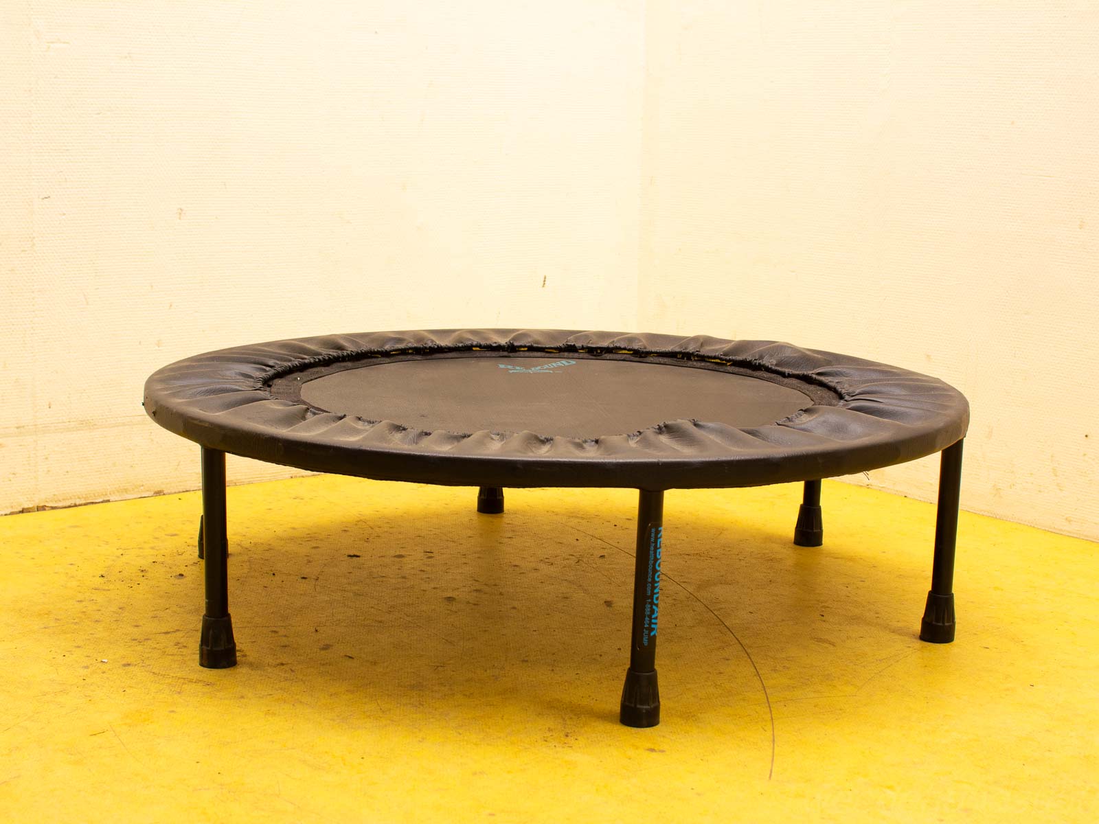 Compact mini trampoline with safety padding for indoor exercise and fun in small spaces.