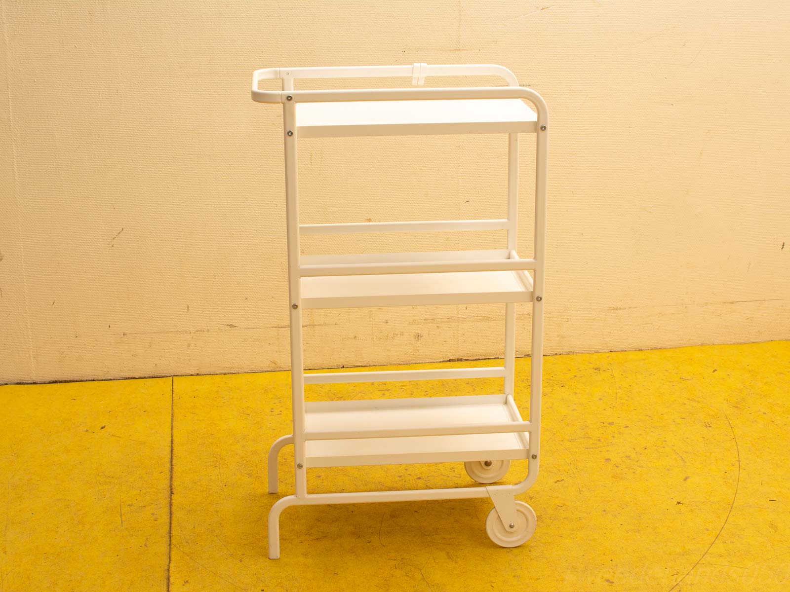 Sleek white metal cart with three shelves for versatile storage and display in any space.