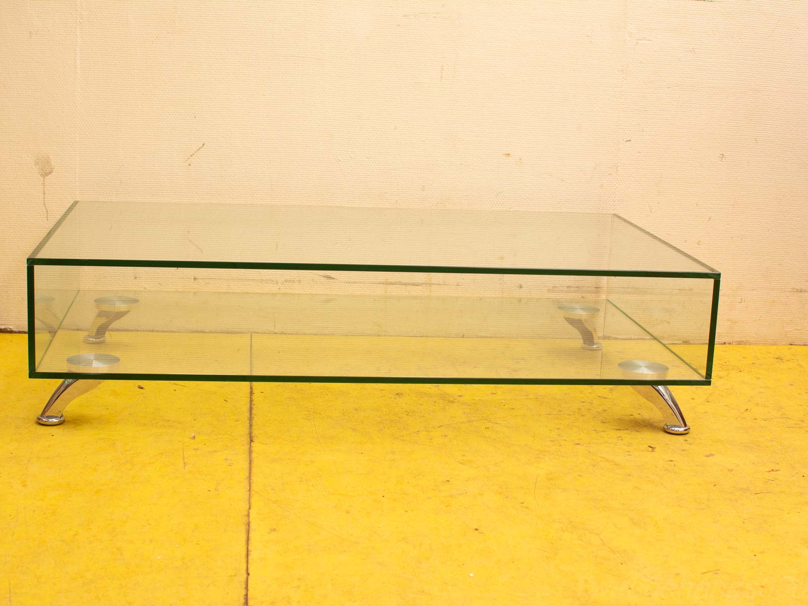 Sleek modern glass coffee table with chrome legs, perfect for contemporary living spaces.