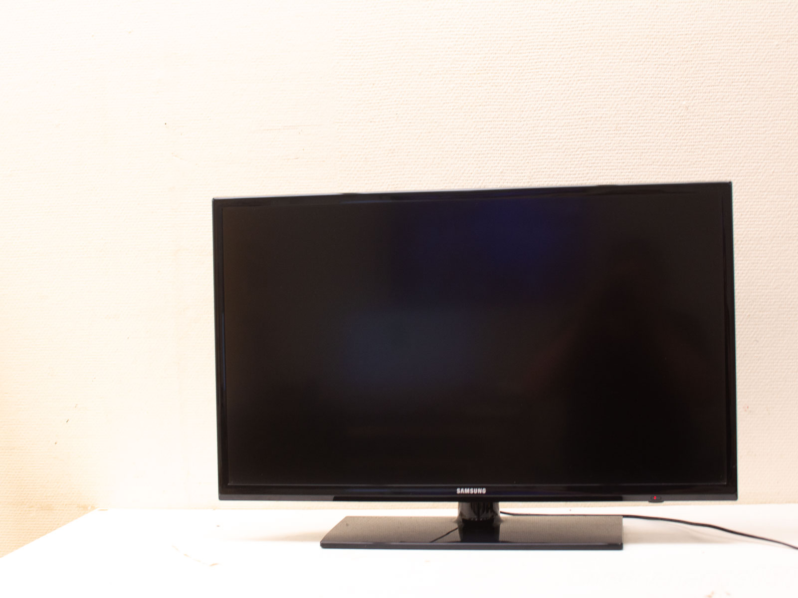 Sleek Samsung TV on a minimalist stand, enhancing modern decor with elegant simplicity.