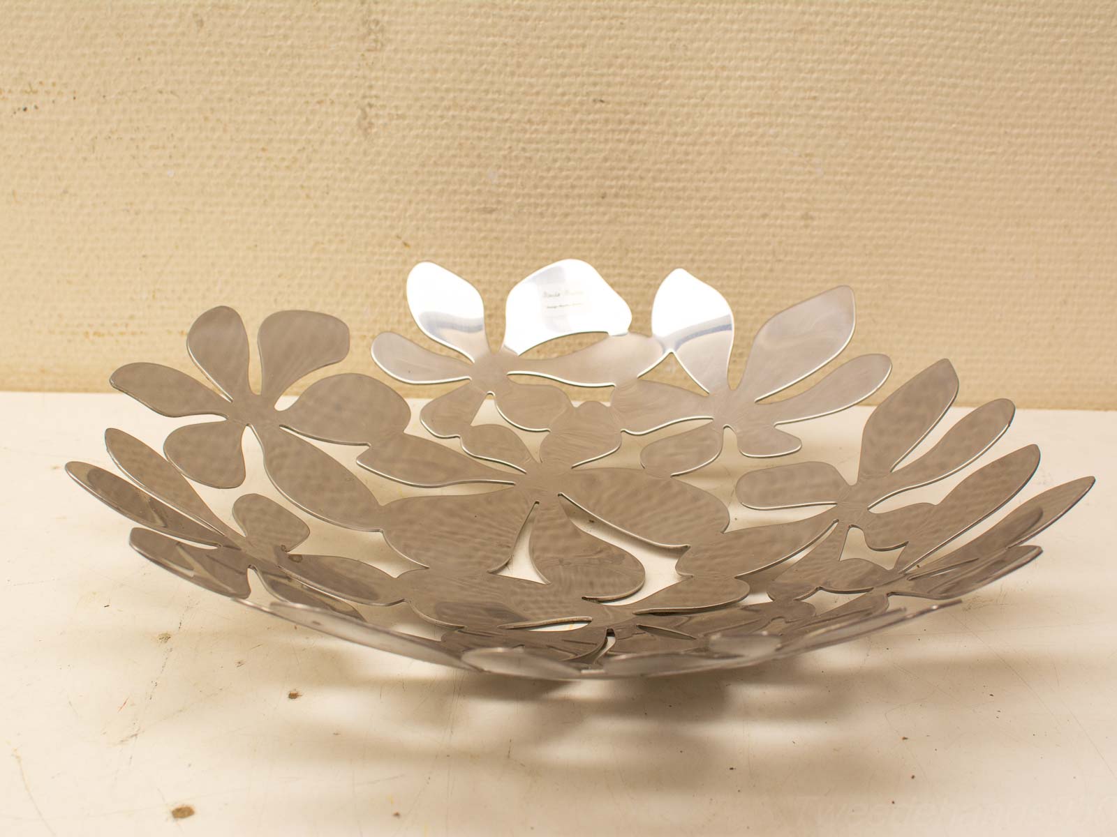 Elegant stainless steel bowl with floral cut-outs, perfect for decor and serving.