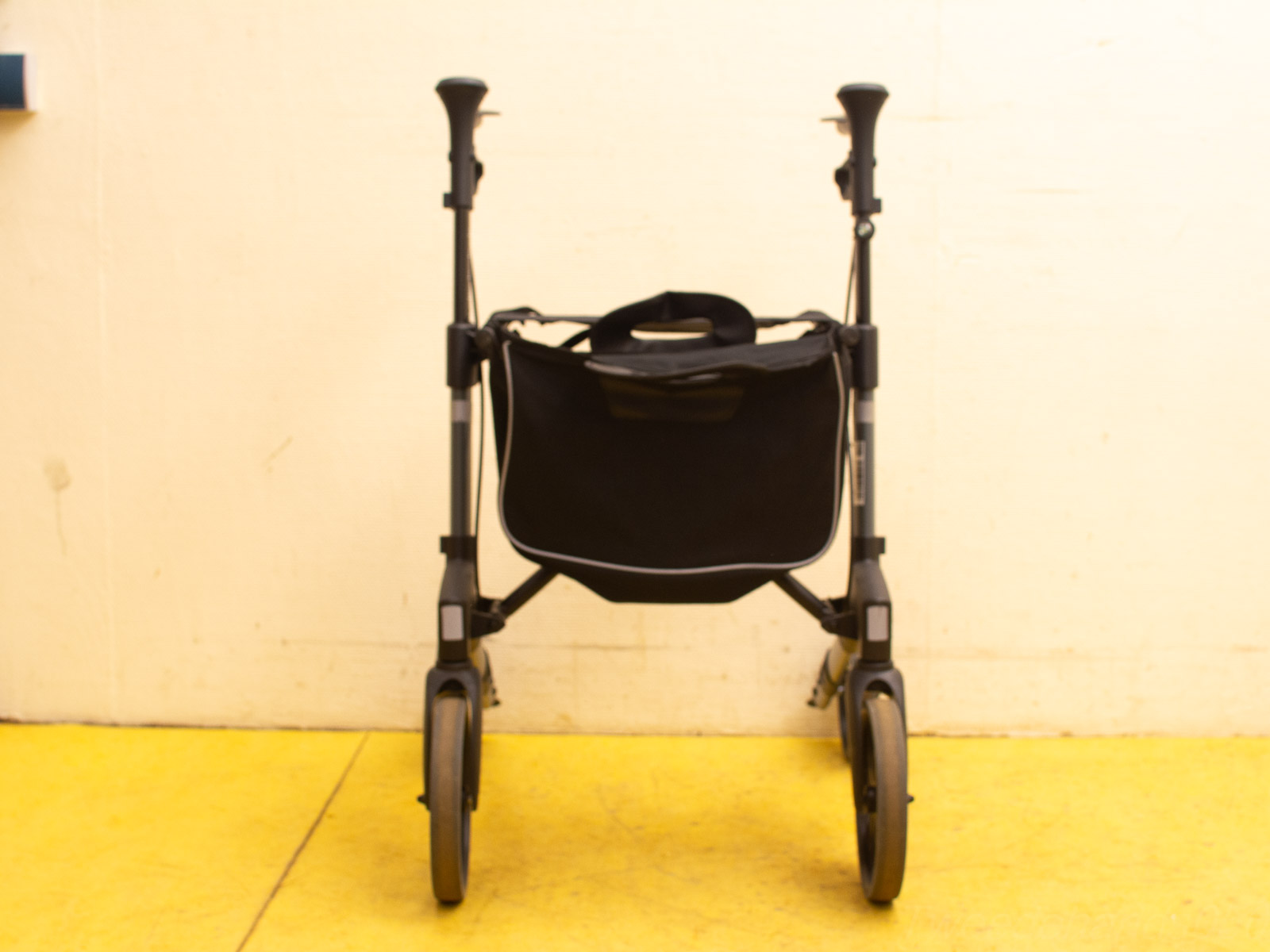 Stylish second-hand walker with bag, four wheels for easy mobility and modern design.