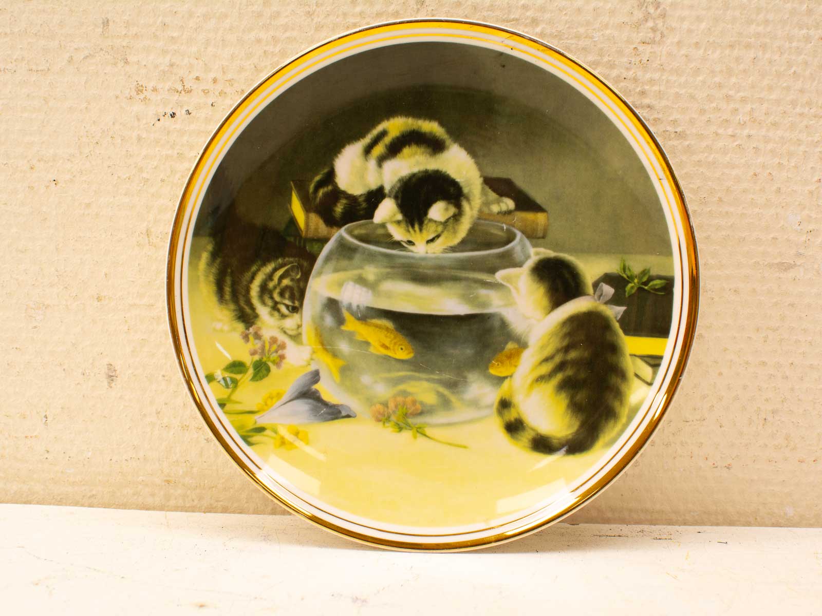 Charming porcelain plate featuring playful cats and a fishbowl with goldfish, perfect for collectors.