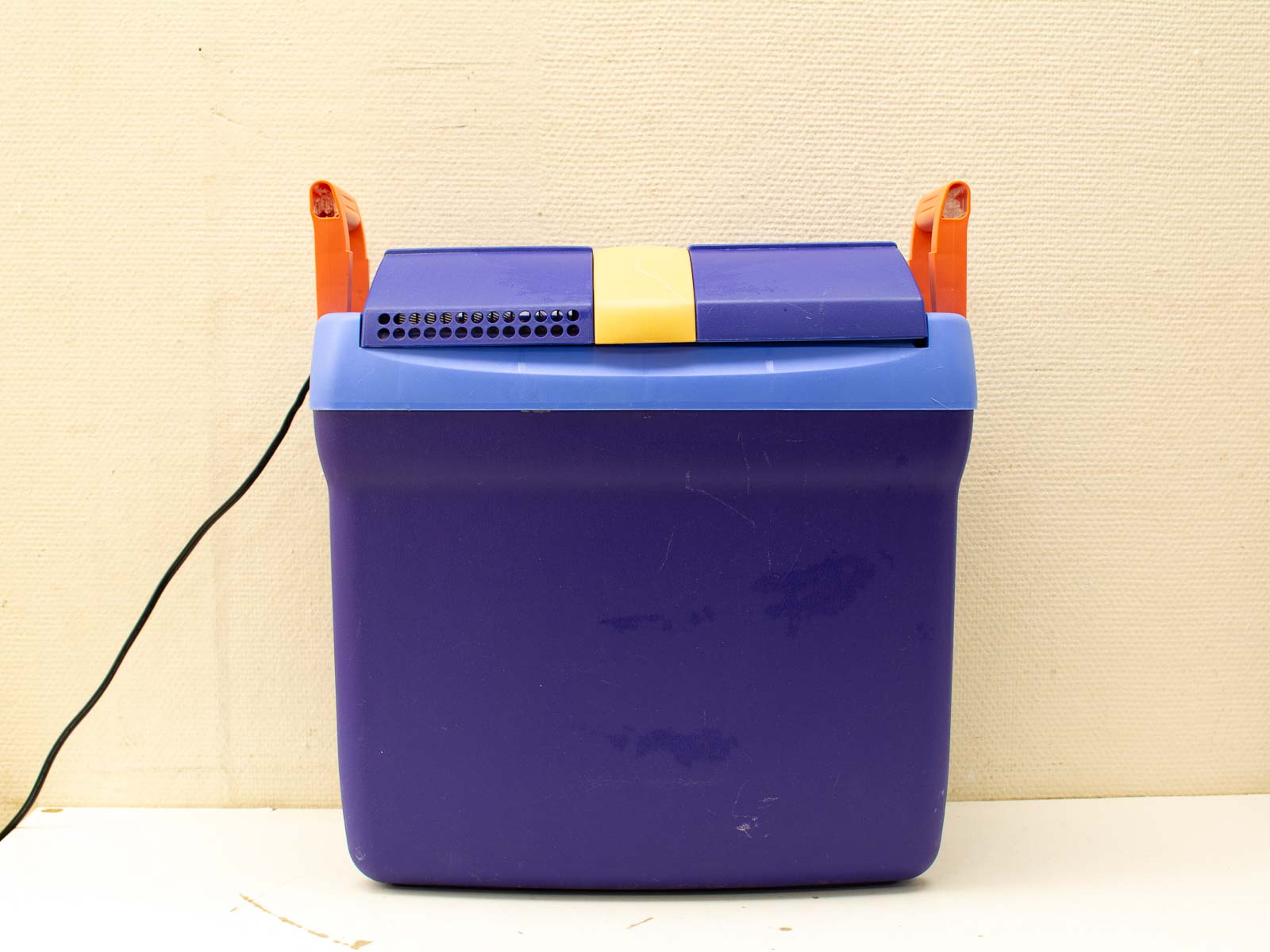 Vibrant purple cooler with yellow stripe and blue lid, perfect for outdoor adventures.