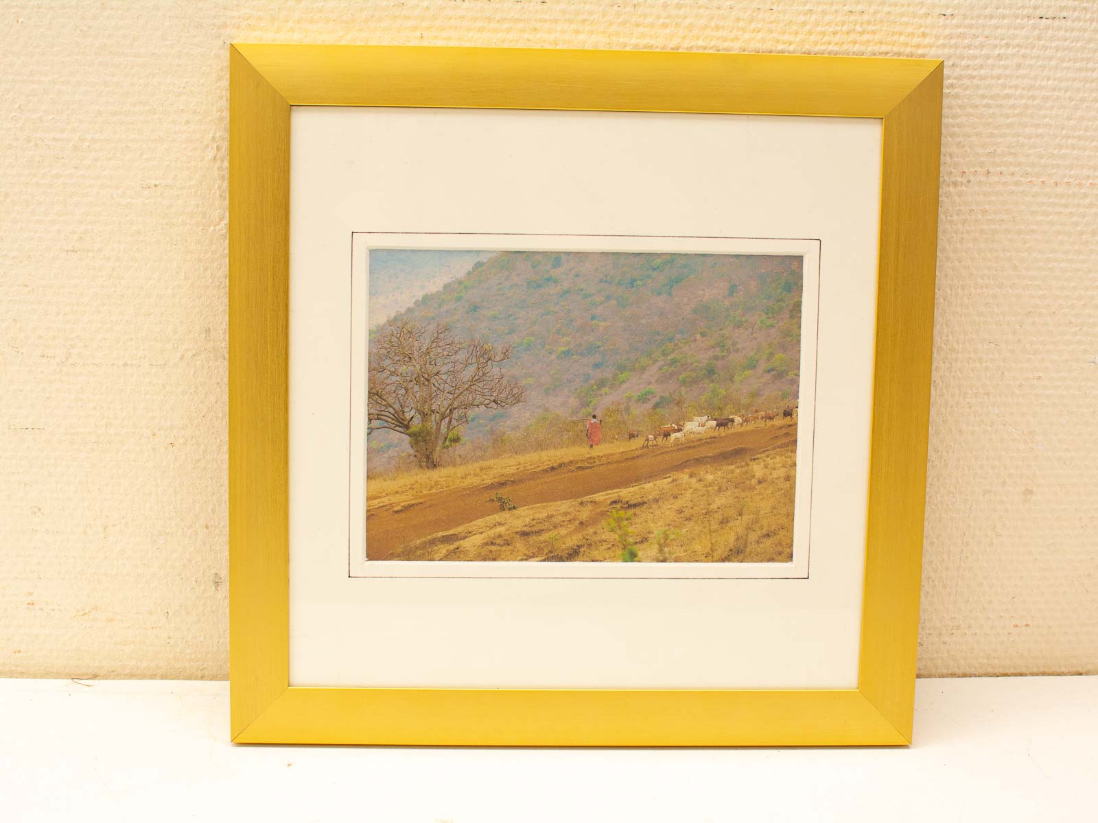 Rustic landscape with dirt path, cattle herd, and serene hills under a clear blue sky.