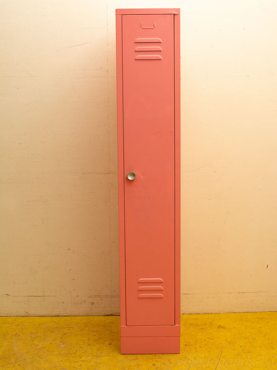 Coral pink vintage locker with ventilation slits, perfect for small spaces and nostalgic style.