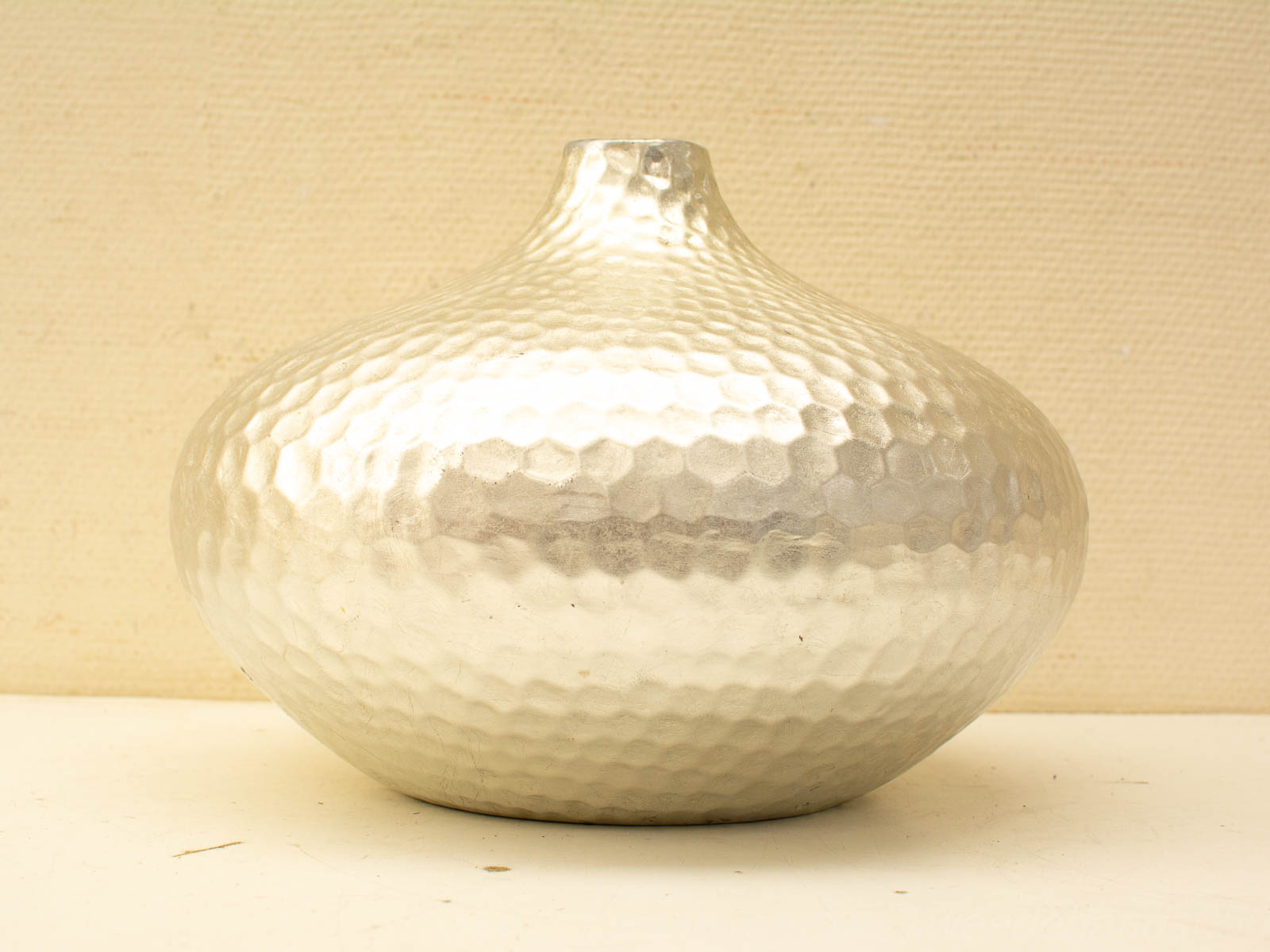 Elegant hammered metal vase with a unique bulbous shape, perfect for floral displays or decor.