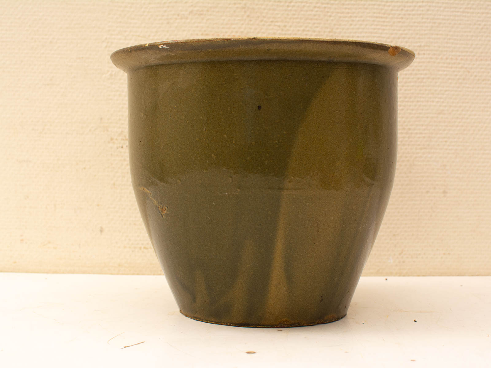 Vintage olive green ceramic pot with glossy glaze and rustic charm, perfect for plants or decor.