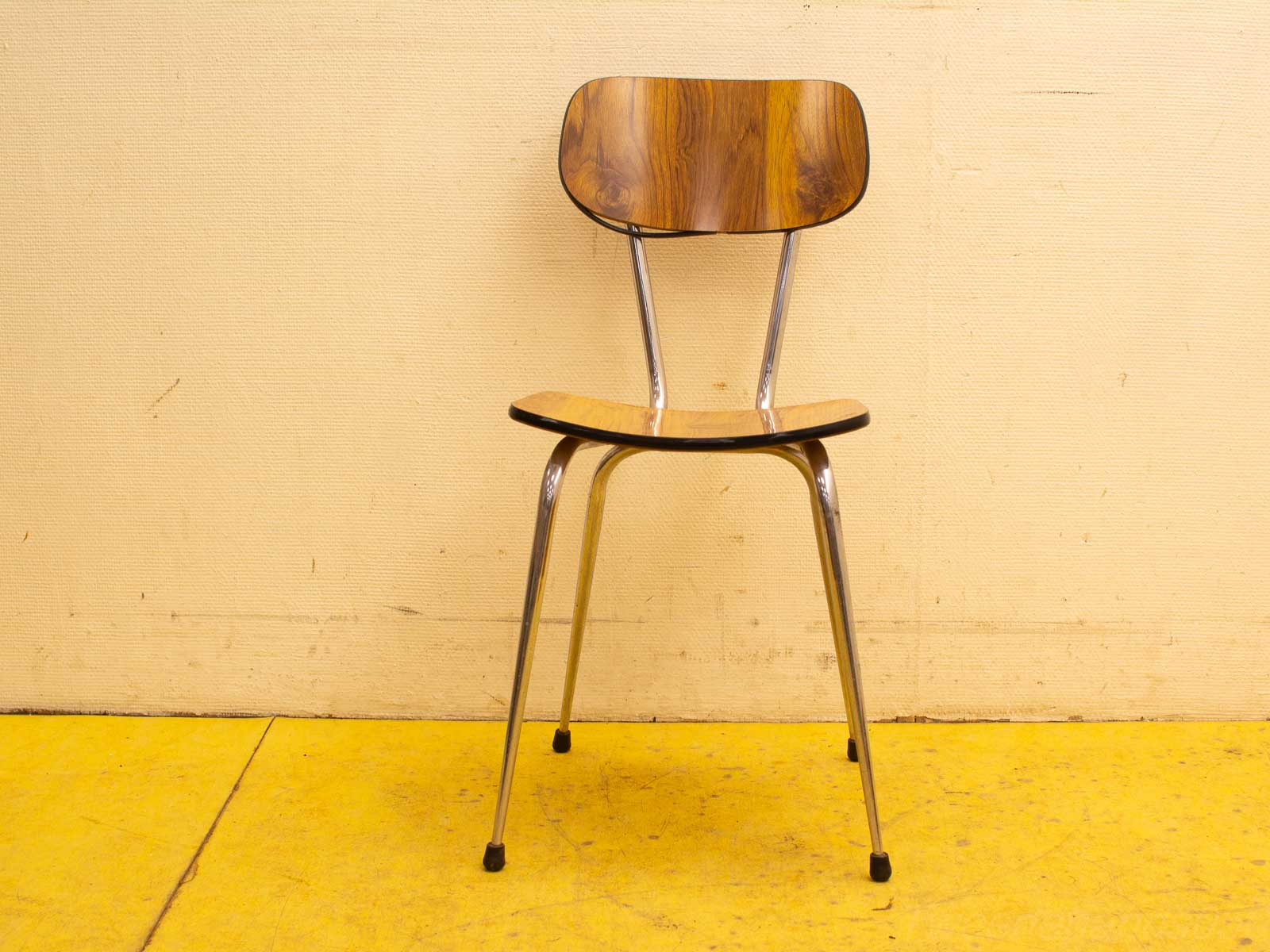 Stylish wooden chair with chrome legs, perfect for modern dining and office settings.