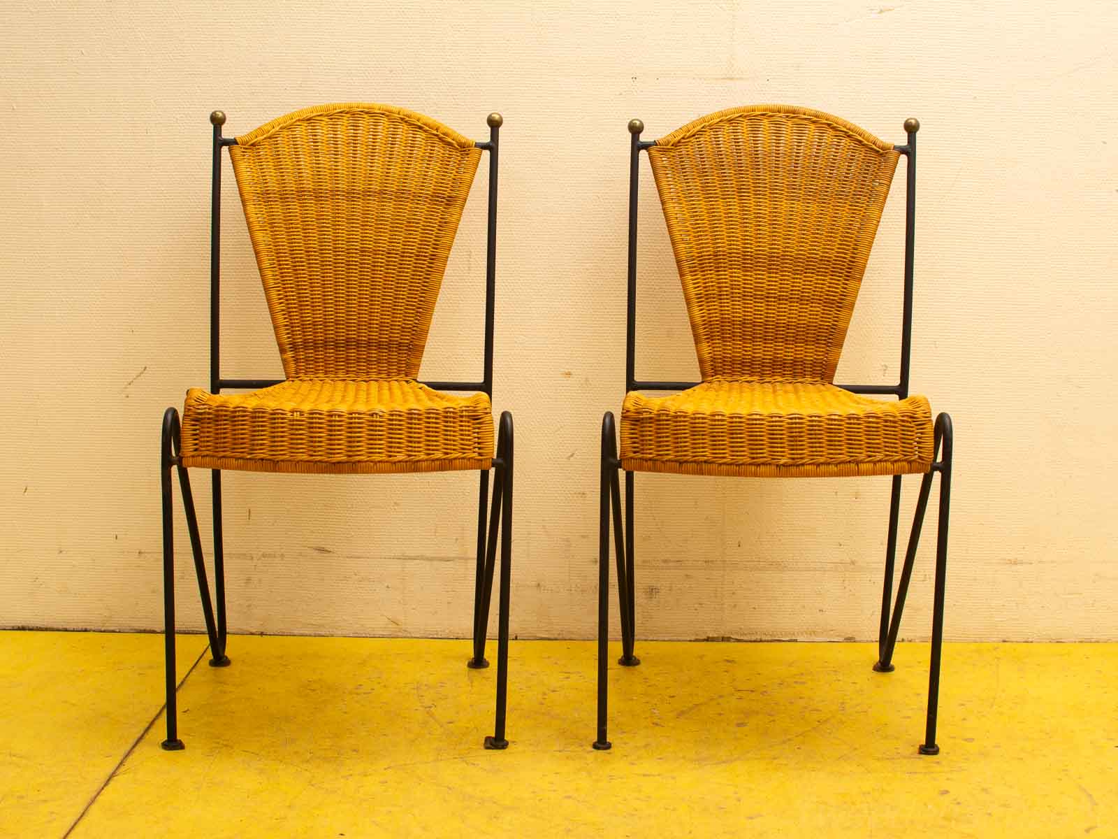 Stylish vintage woven chairs with black metal frames, perfect for dining or patio settings.