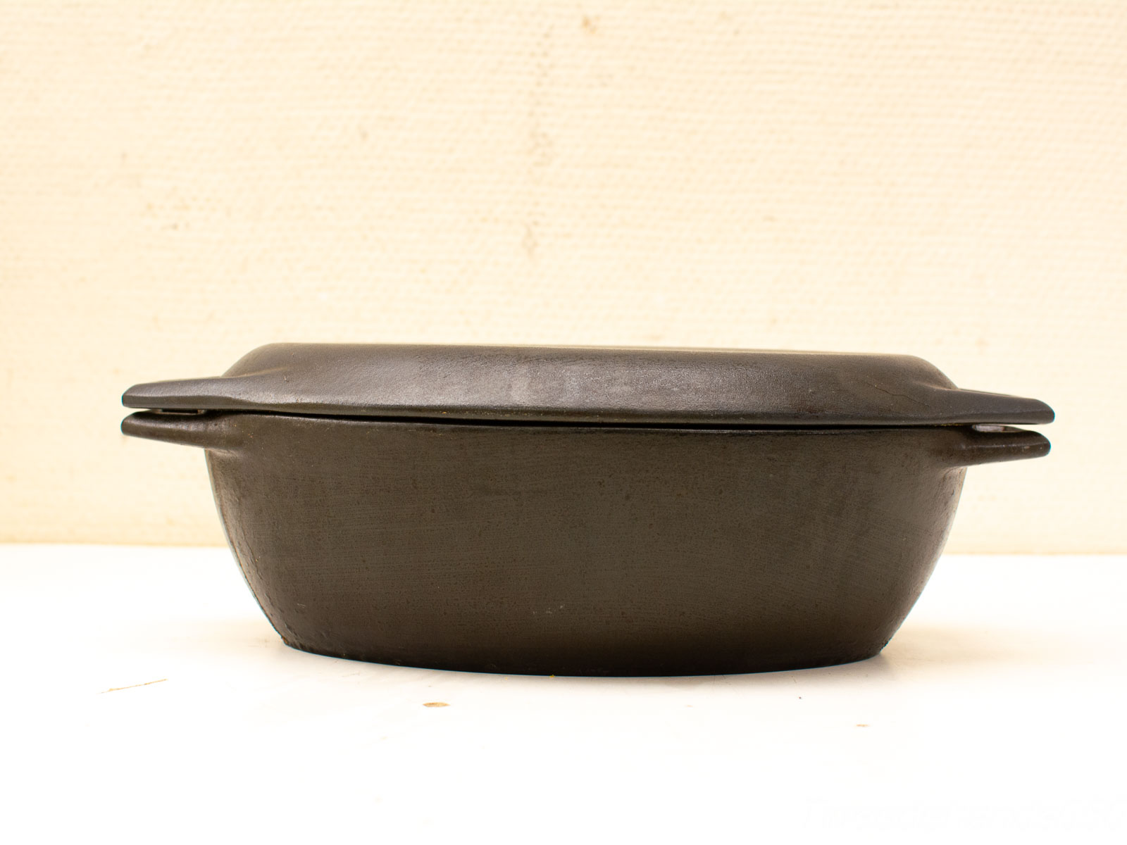 Handcrafted clay cooking pot with lid and handles, perfect for versatile culinary use.