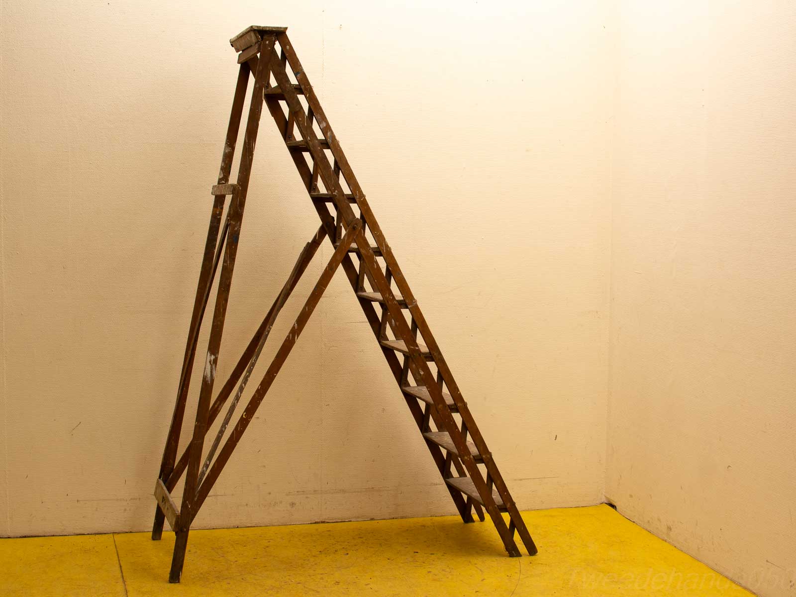 Weathered vintage wooden ladder against a light wall, showcasing rustic charm and creative potential.