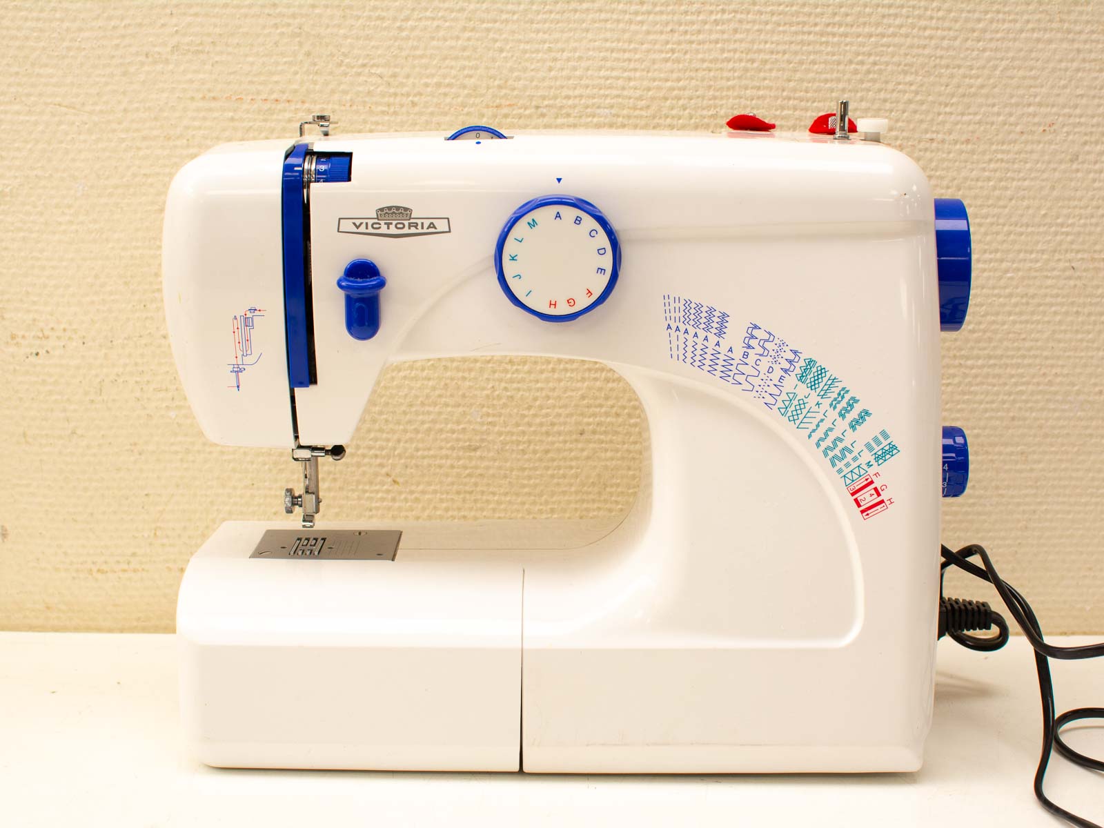 Versatile Victoria sewing machine in sleek white, blue, and red, perfect for all skill levels.