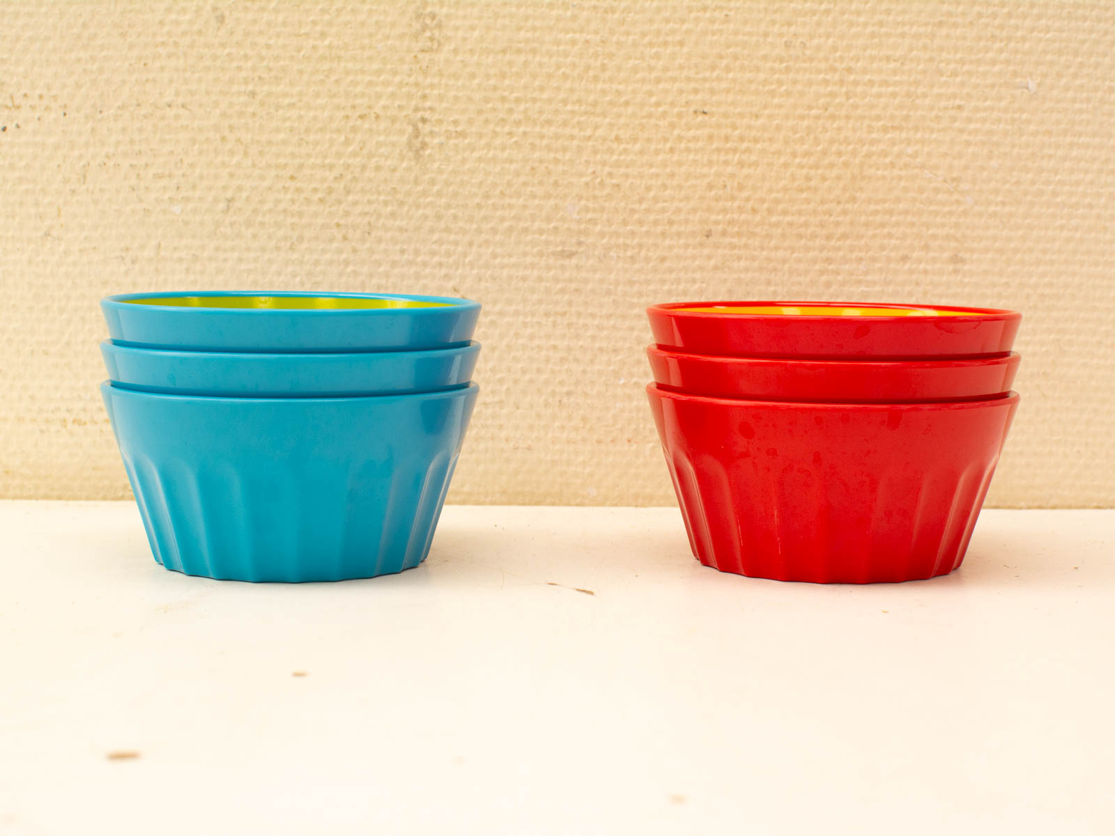 Vibrant vintage bowls in turquoise and red with yellow interiors, perfect for serving or decor.