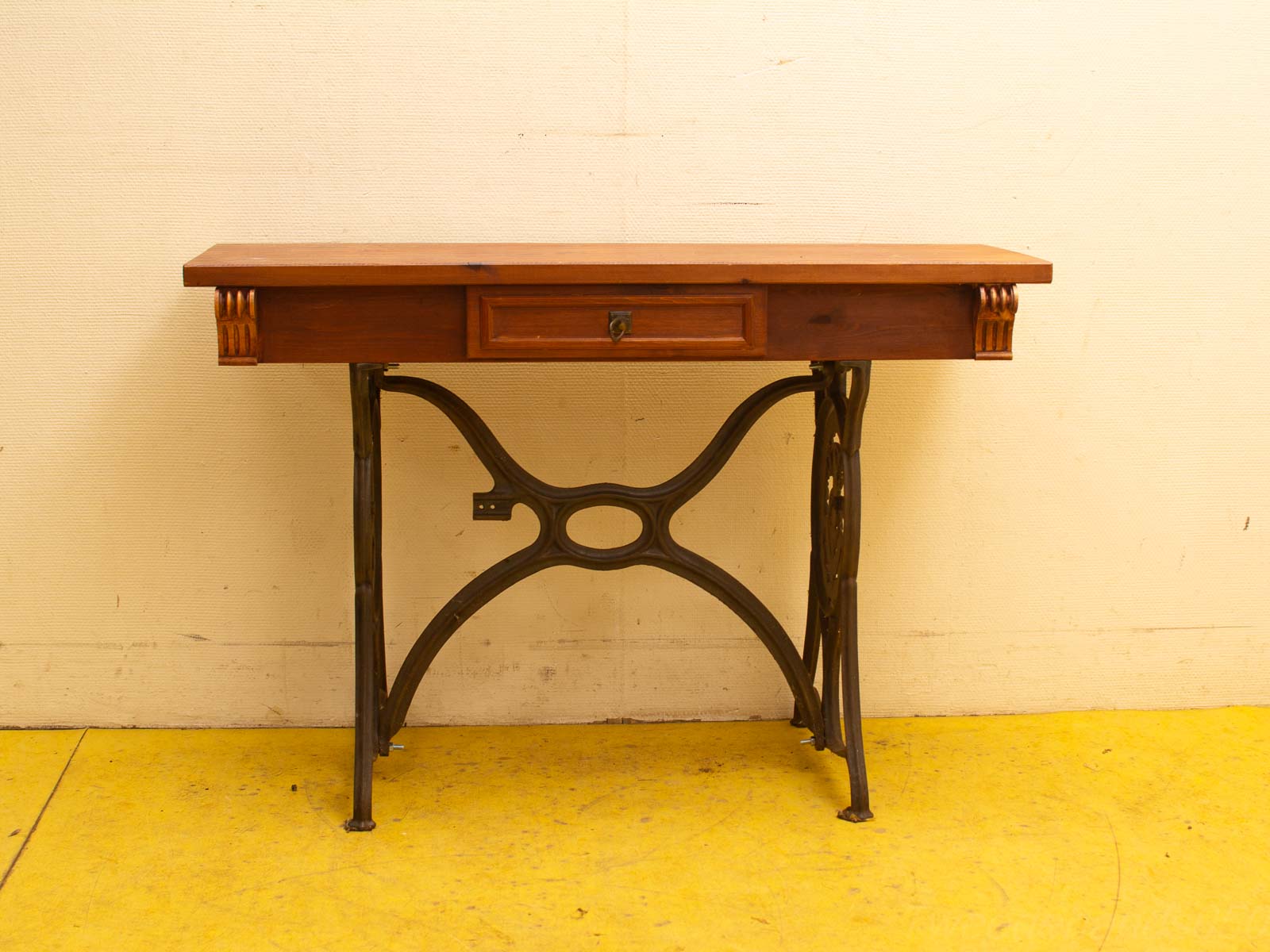 Vintage console table with wooden top, metal legs, and functional drawer for stylish storage.