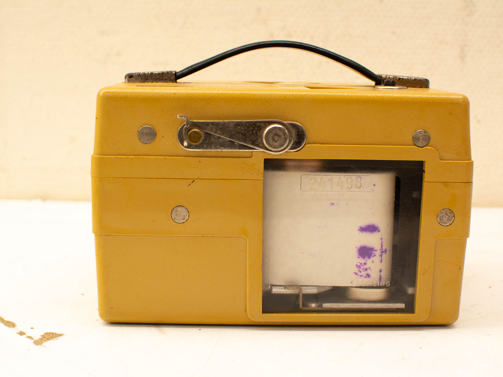 Vintage yellow device with transparent window and metal fasteners, ideal for tech history enthusiasts.