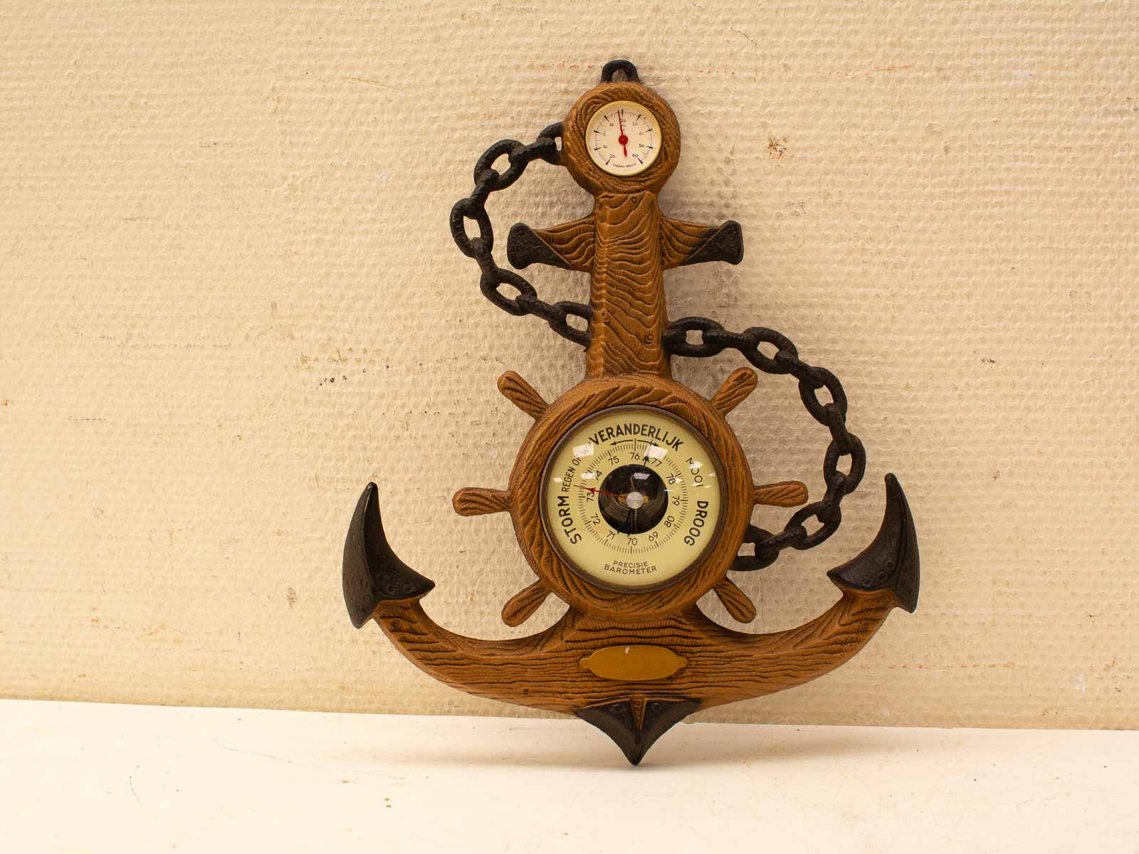 Rustic wooden anchor barometer and thermometer, perfect for nautical décor and weather forecasting.