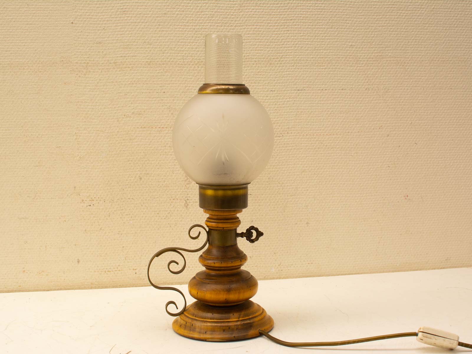 Vintage wooden lamp with brass accents and etched frosted glass shade for elegant decor.