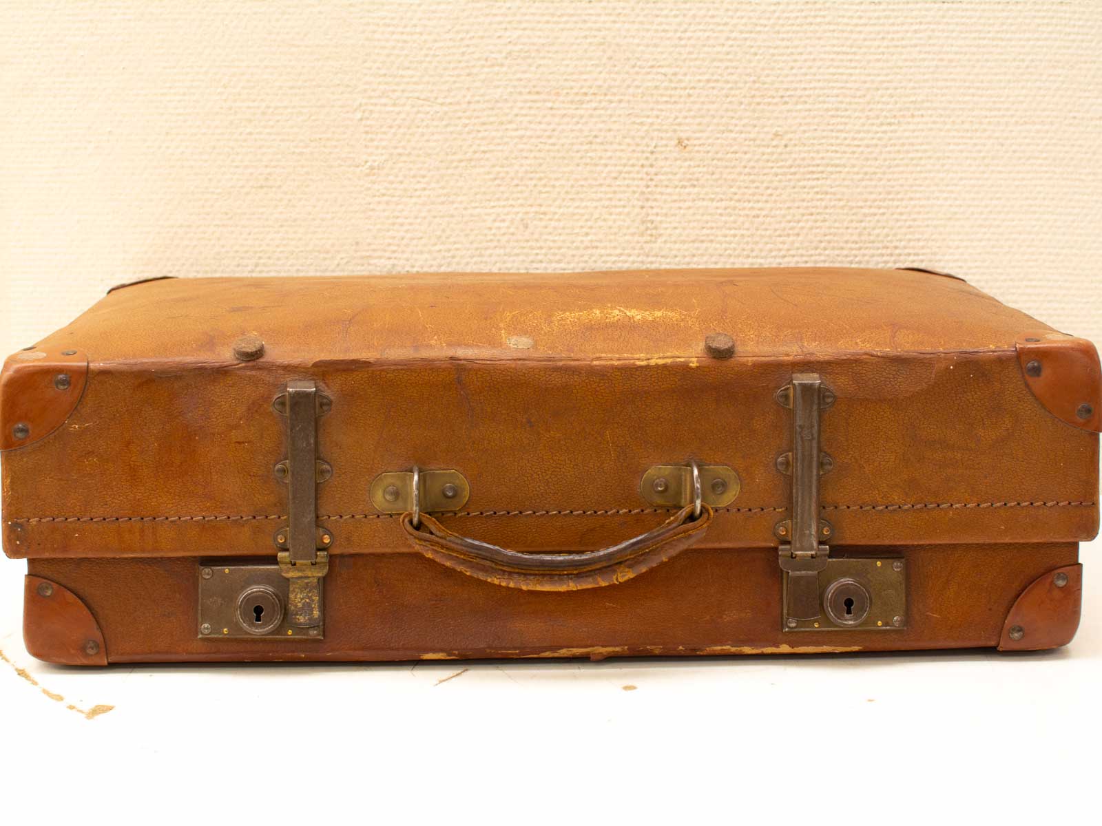 Timeless vintage leather suitcase with patina, sturdy metal clasps, and rich travel history.