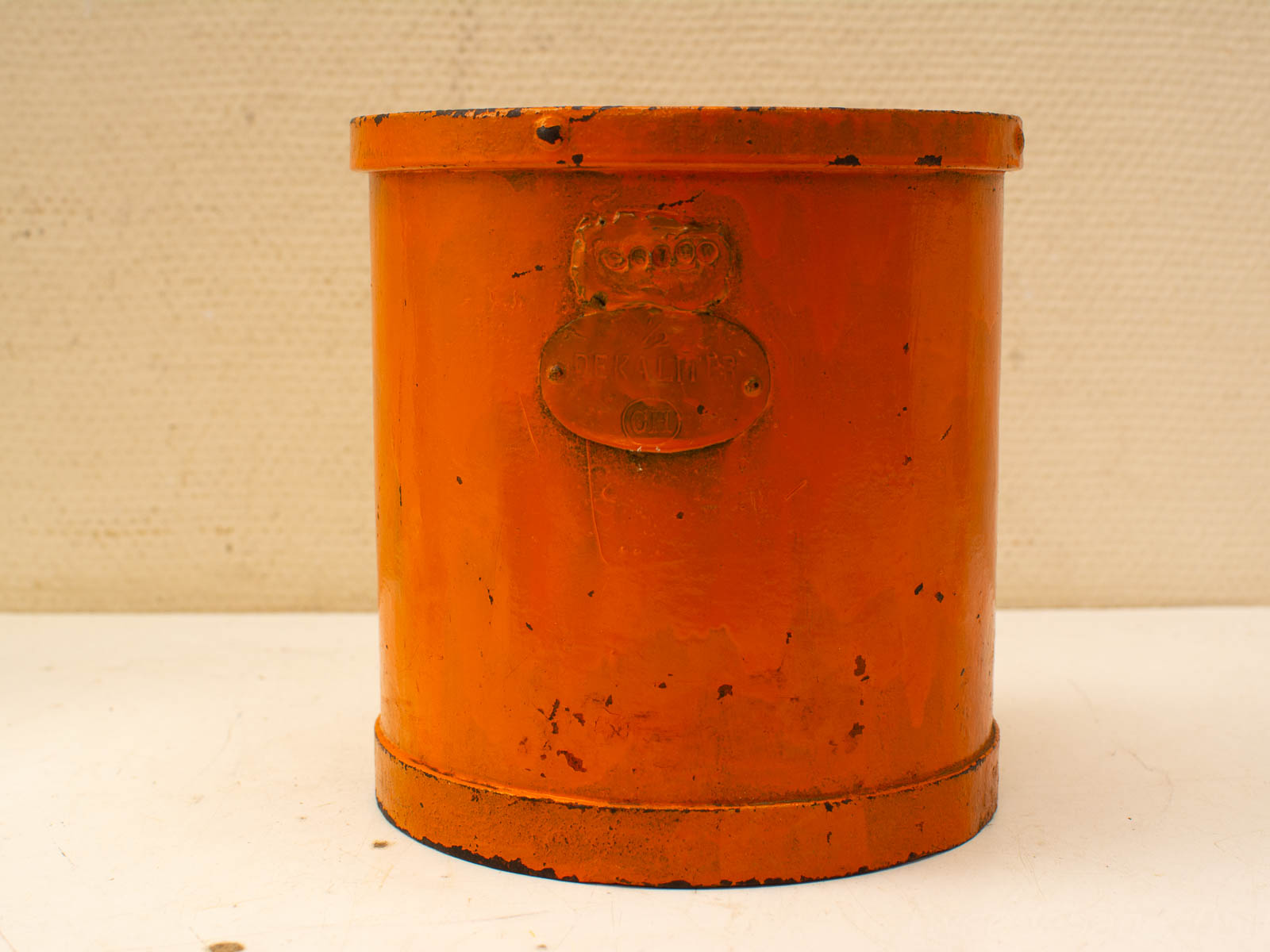 Charming vintage orange container with embossed label, showcasing unique character and nostalgia.