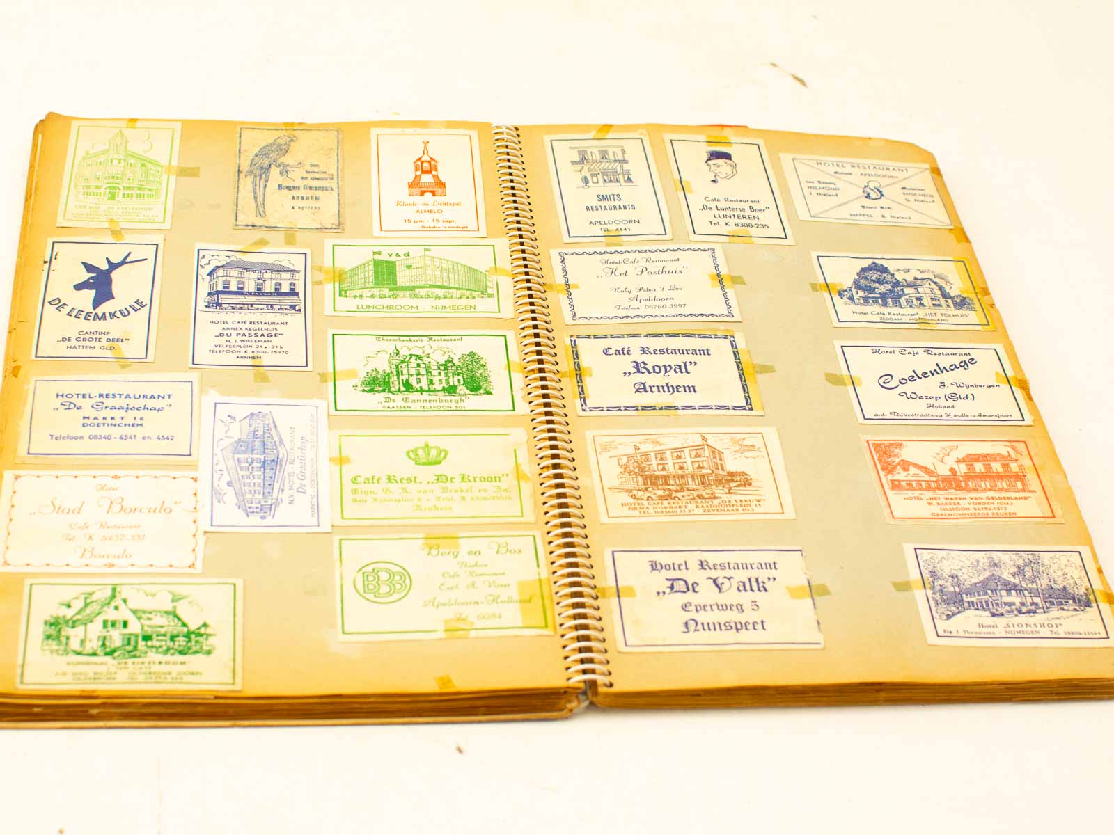 Nostalgic scrapbook of vintage restaurant and hotel business cards from the Netherlands.