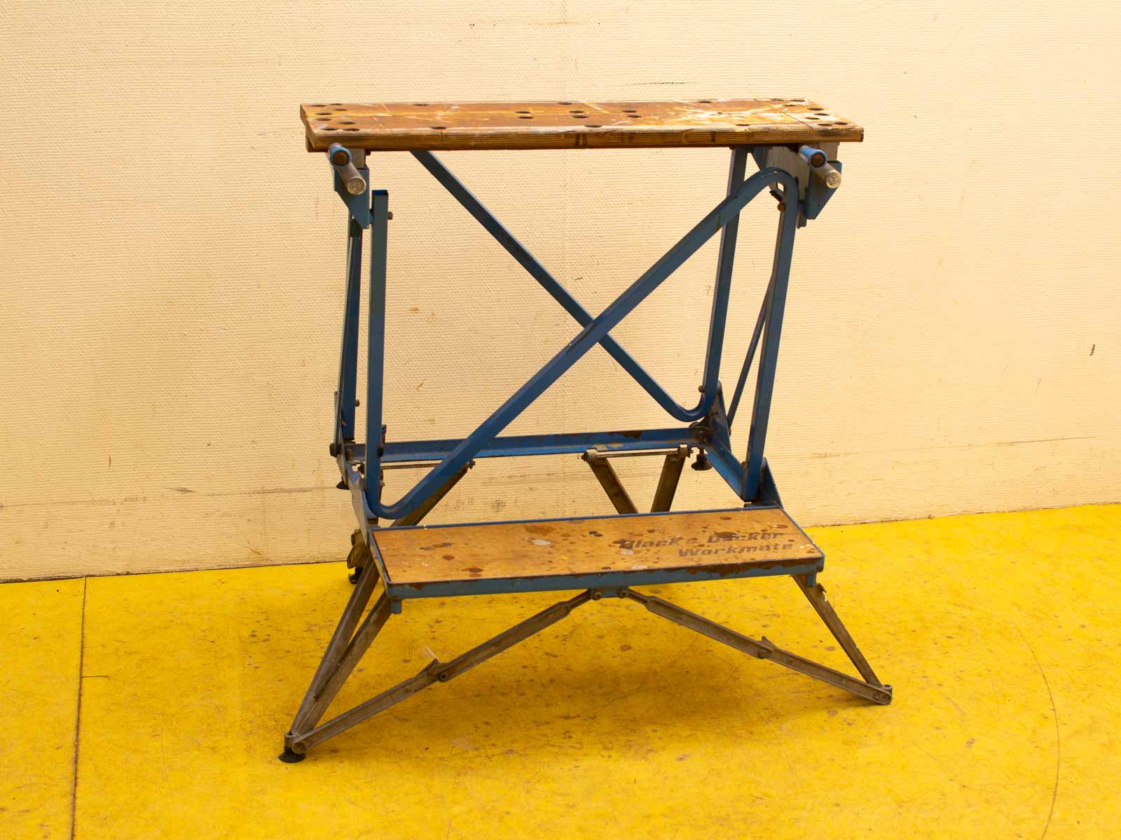 Versatile vintage foldable workbench with wooden top and blue steel frame for DIY projects.