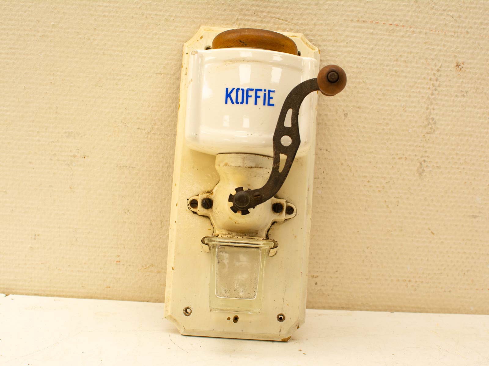 Vintage coffee grinder with a glossy ceramic hopper, perfect for nostalgic kitchen decor.